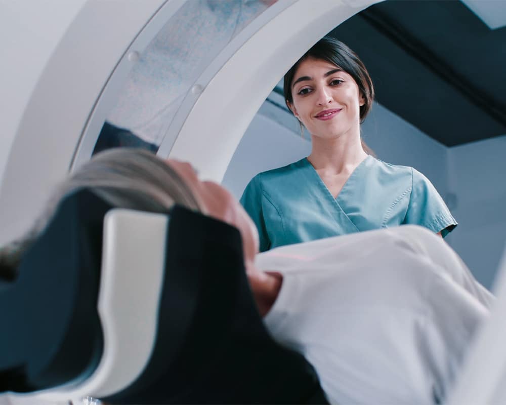 Person getting MRI scan while doctor watches over them.